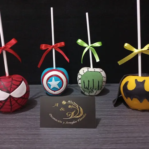 Cuatro manzanas decoradas de superhéroes: Spider-Man, Capitán América, Hulk y Batman