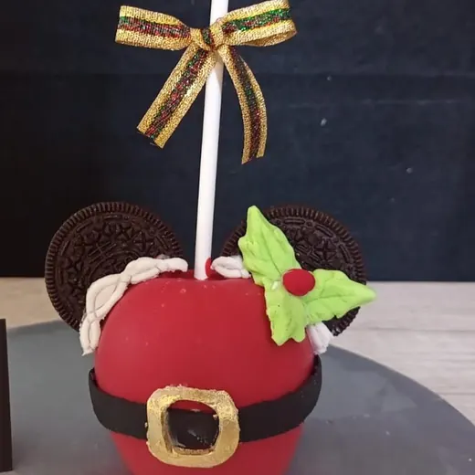 Manzana navideña roja con cinturón de Santa y moño dorado